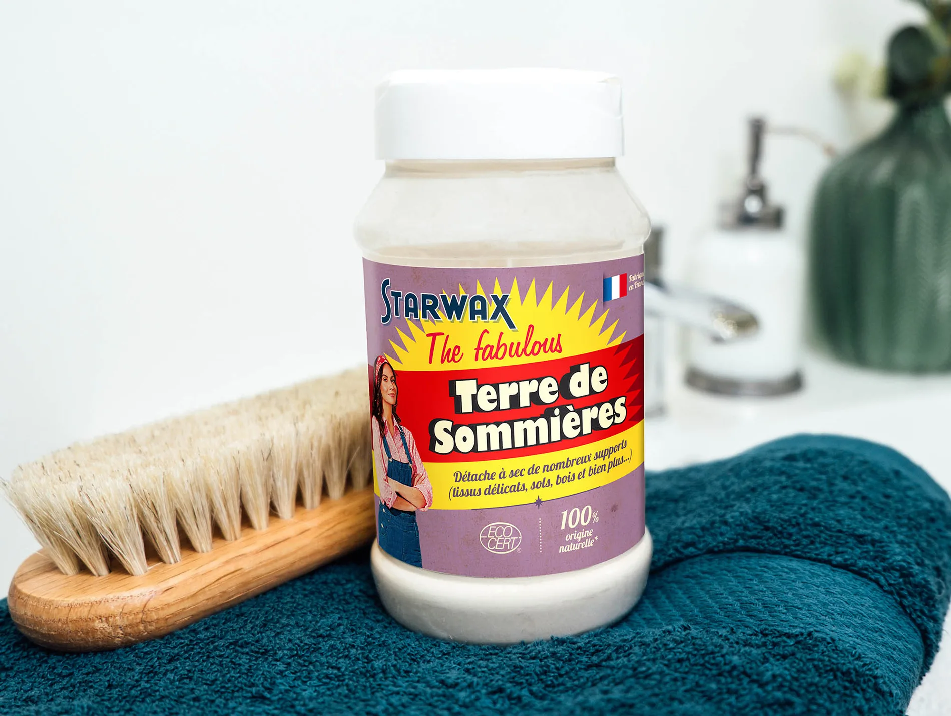 Produit Terre de Sommières de Starwax, utilisé pour le nettoyage à sec de divers supports, avec une brosse à poils naturels en arrière-plan.