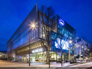 Vue extérieure du cinéma UGC Ciné Cité à Paris, illuminé en soirée.