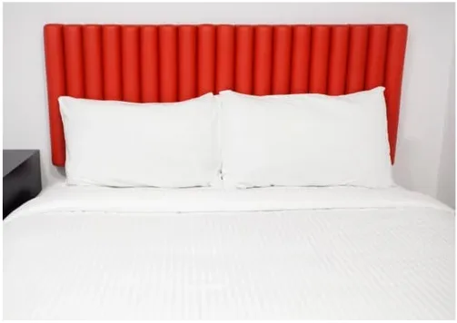 Tête de lit rouge avec draps blancs propres, mise en garde contre les cachettes des punaises de lit