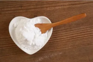 Poudre blanche naturelle dans un bol en forme de cœur. bicarbonate de soude